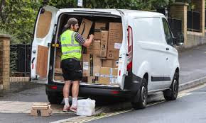 delivery man carrying packages from the back of the bus photo